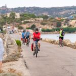 Gruppo di cicloturisti in bici sulla strada tra La Maddalena e Caprera