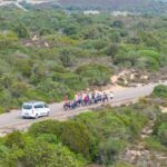 Gruppo in mountain bike su sterrato nella Costa Verde, Sardegna